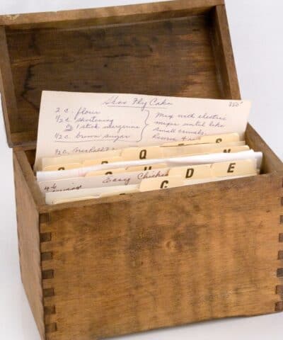 a wooden recipe box with recipes in it