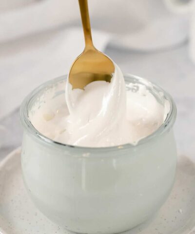 glass jar of marshmallow fluff with a gold spoon in it
