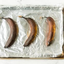 three ripened bananas on a foil lined baking sheet