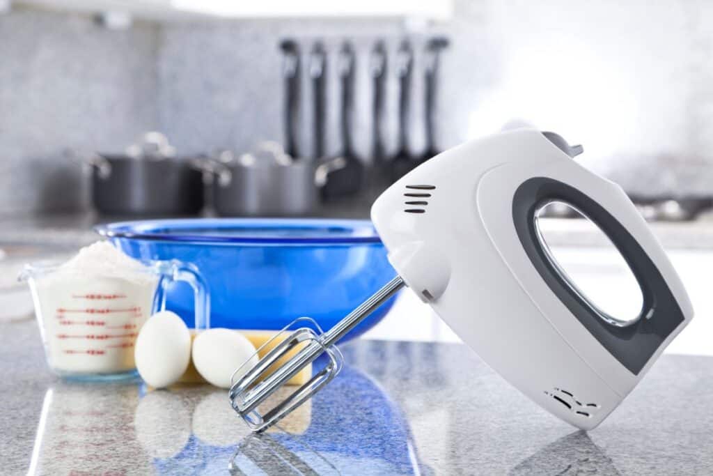 white hand mixer and baking ingredients