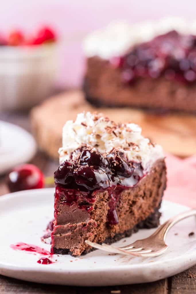 slice of black forest cheesecake on a plate with a fork