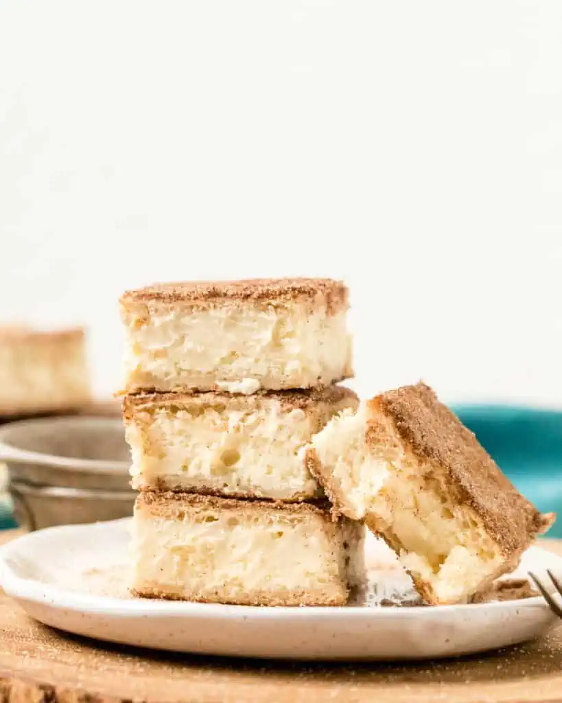 stack of churro cheesecake bars on a plate