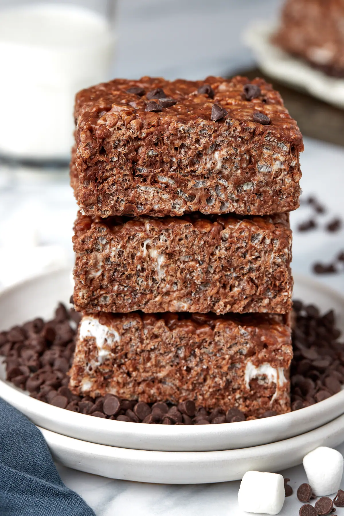 three chocolate rice krispie treats stacked on a plate