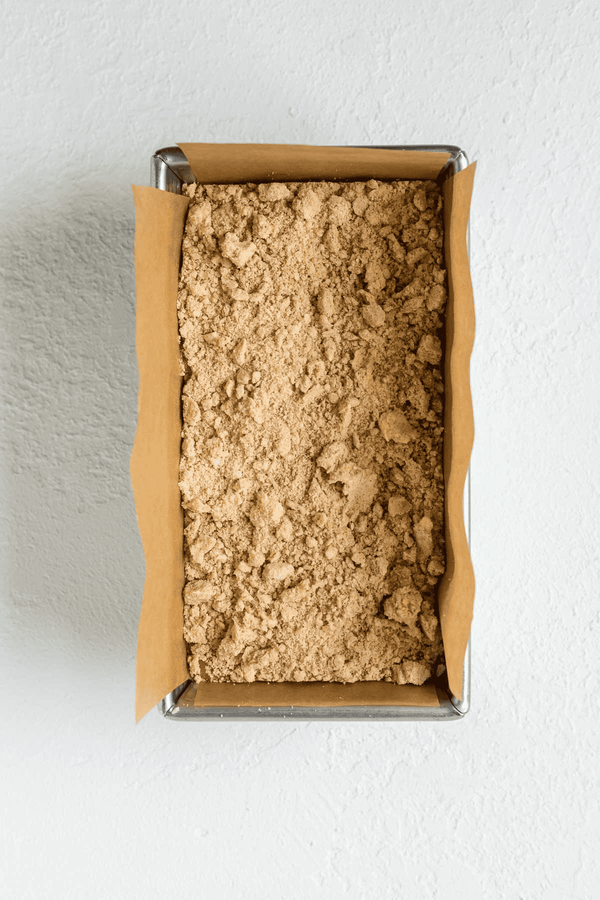 unbaked sweet potato bread in a loaf pan topped with streusel