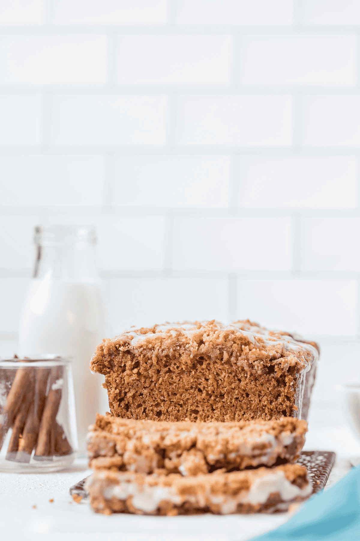 sliced sweet potato bread with a glass of milk and a dish of cinnamon sticks