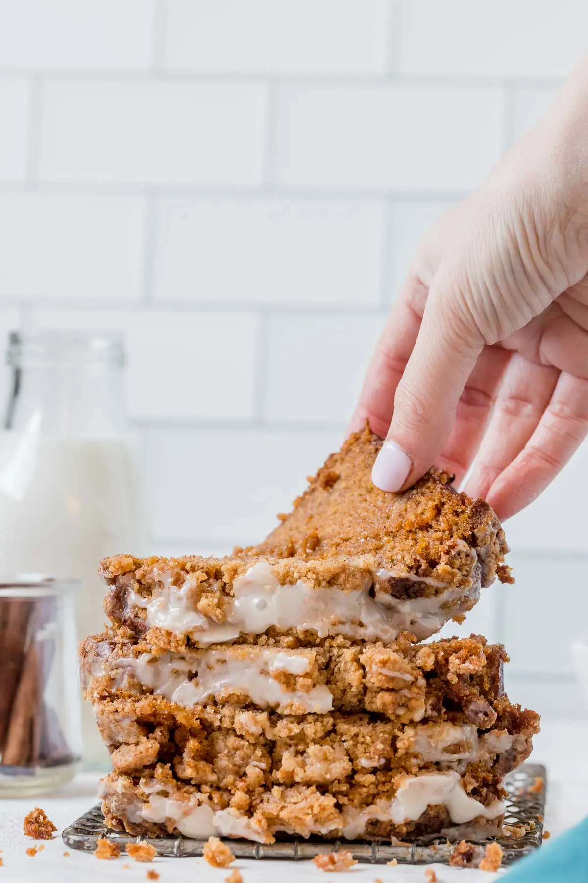 hand grabbing a slice of sweet potato bread from a stack of sweet potato bread