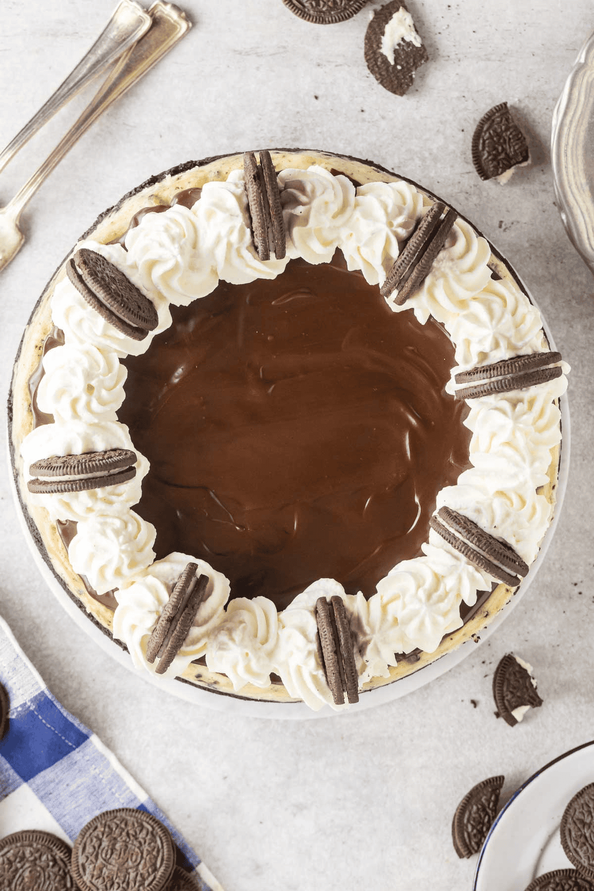 Oreo cheesecake topped with ganache, whipped cream, and Oreos