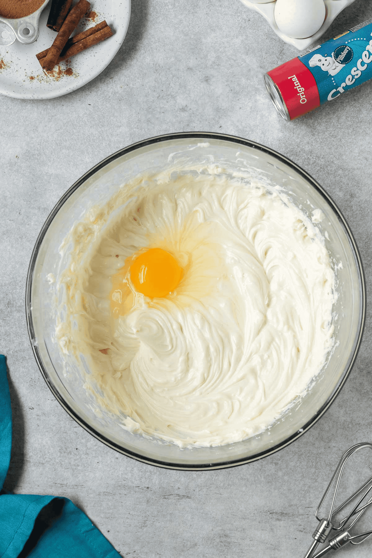 egg added to cheesecake batter in bowl