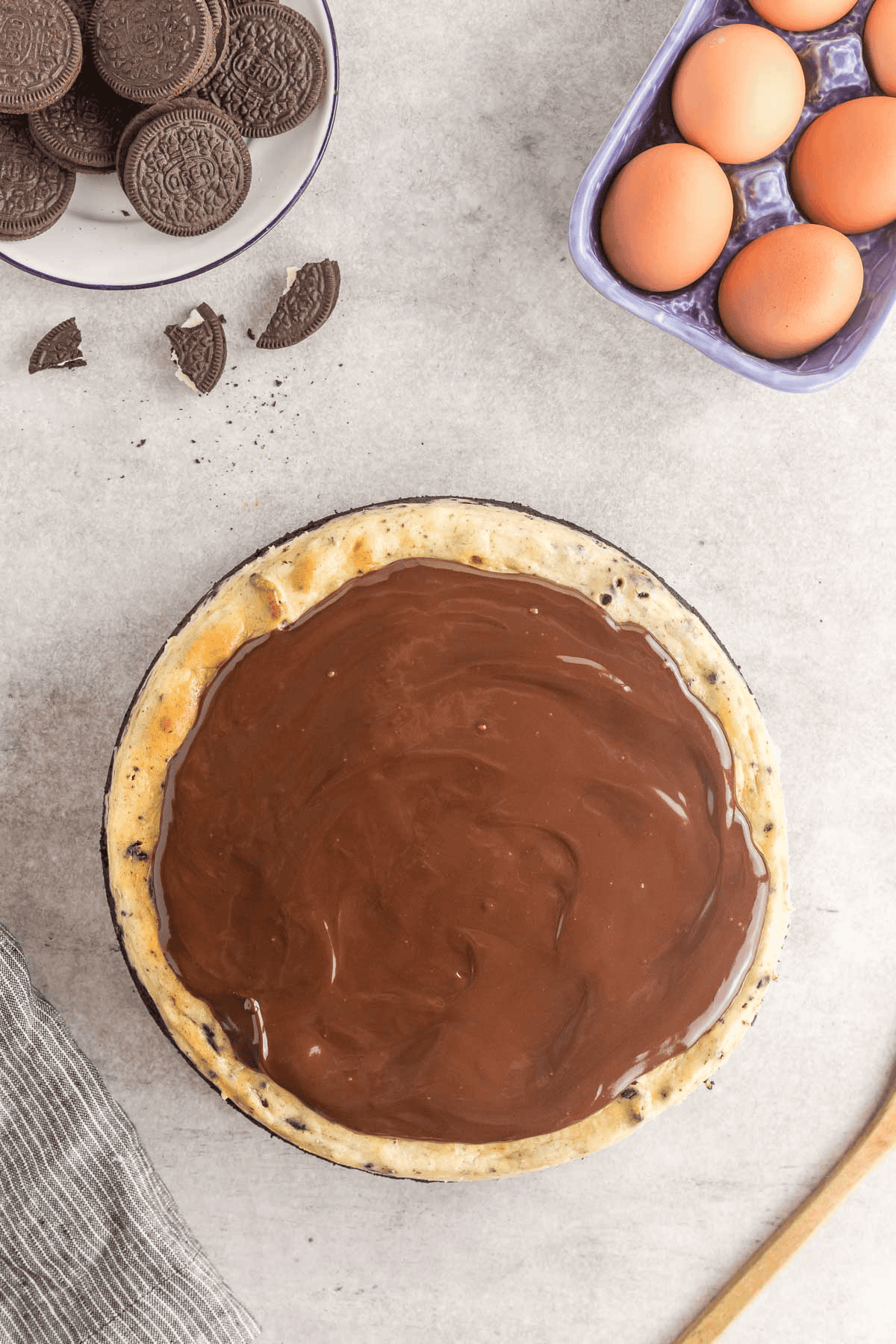 chocolate ganache spread on top of Oreo cheesecake