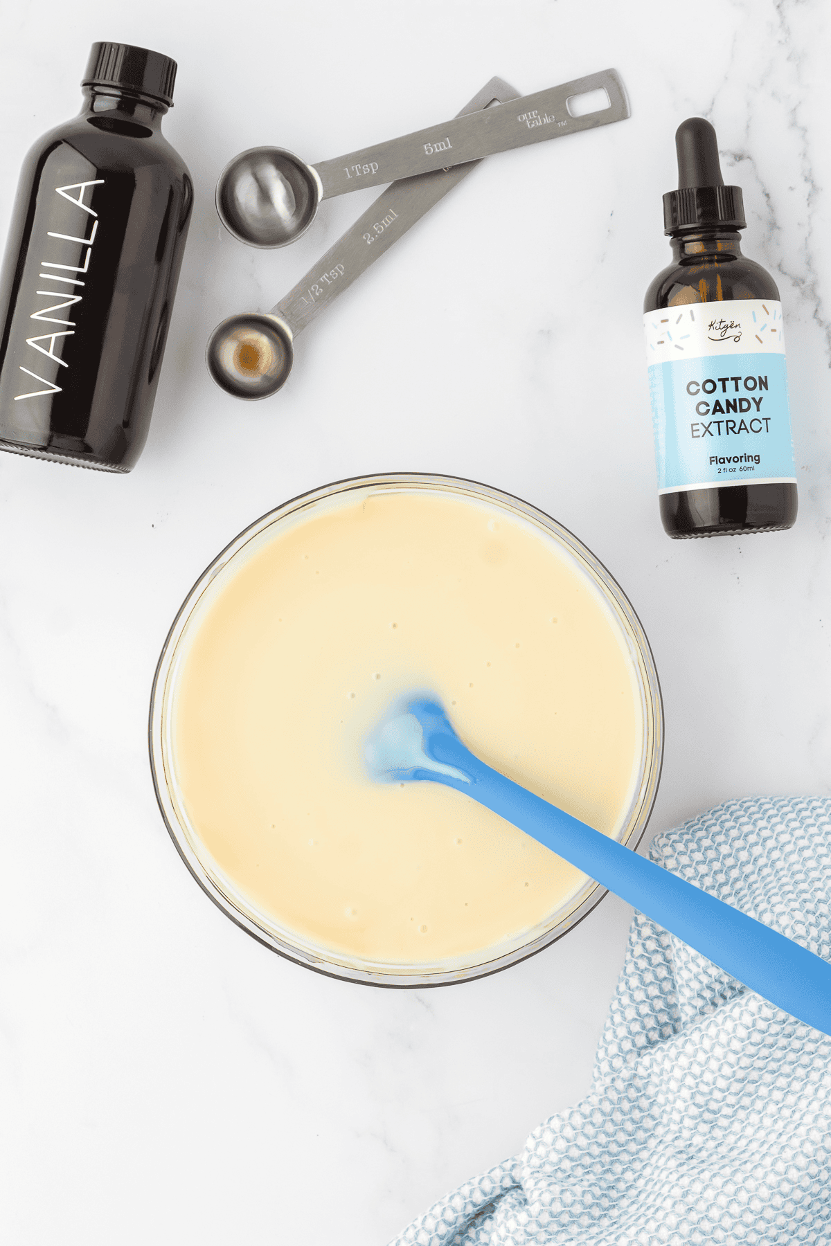 vanilla, cotton candy extract, and sweetened condensed milk in bowl with spatula