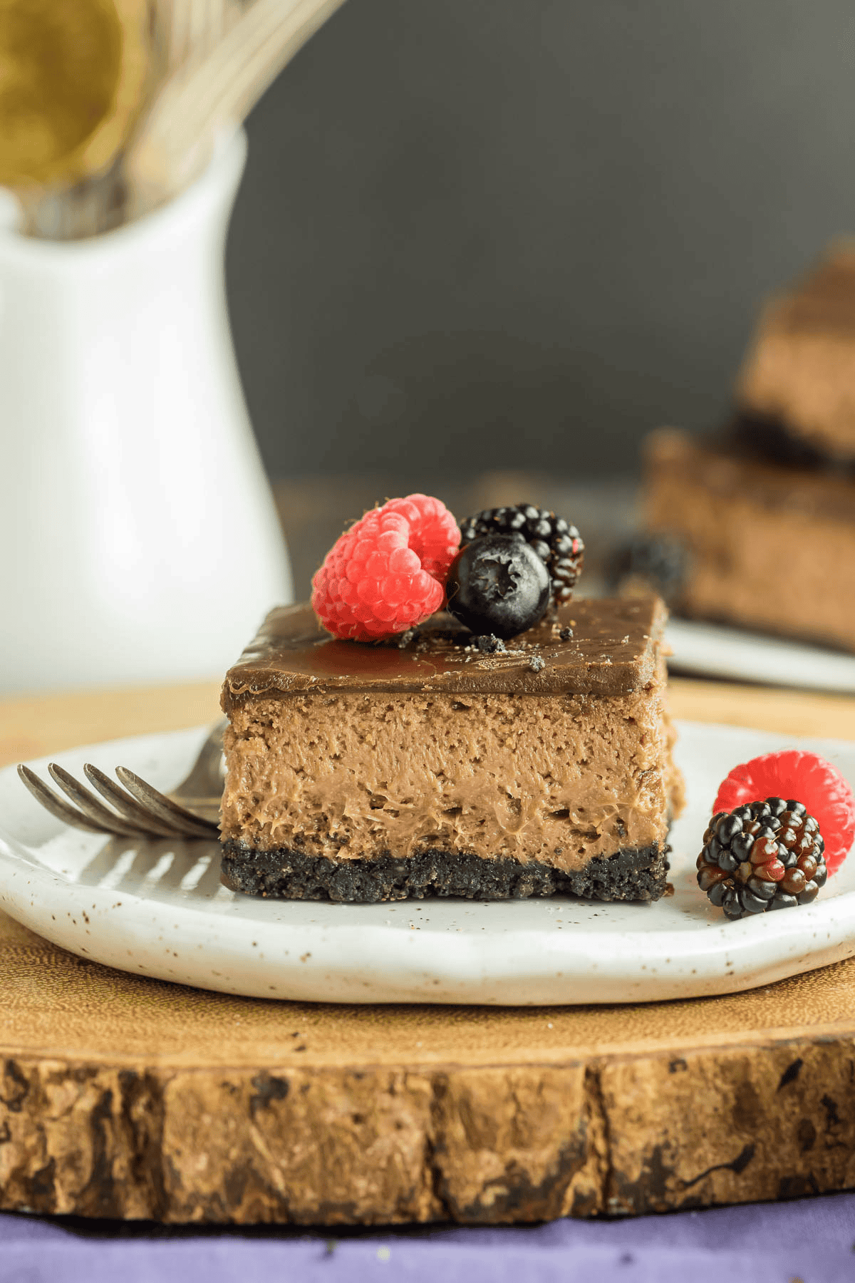 Nutella cheesecake bar on a plate with a fork and berries