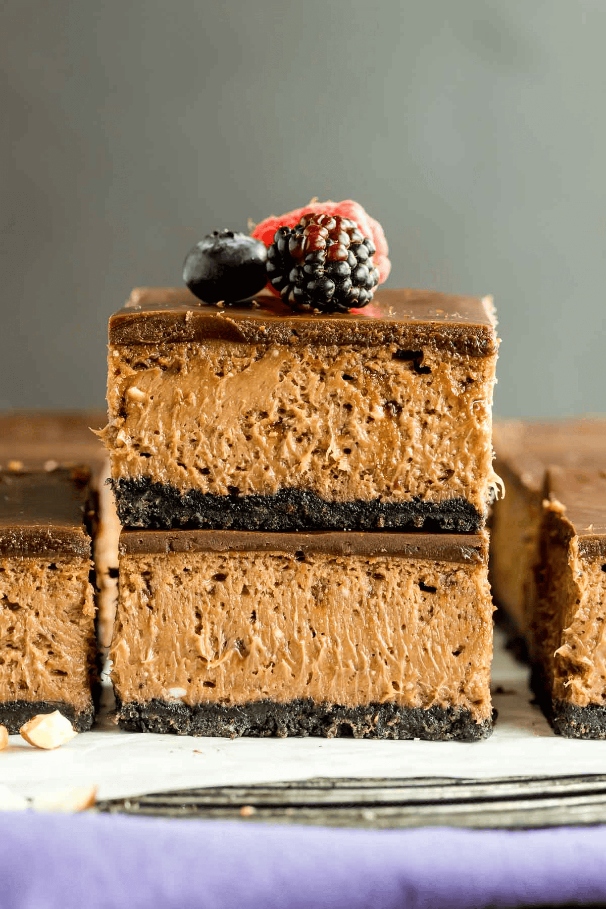 two Nutella cheesecake bars stacked and topped with berries