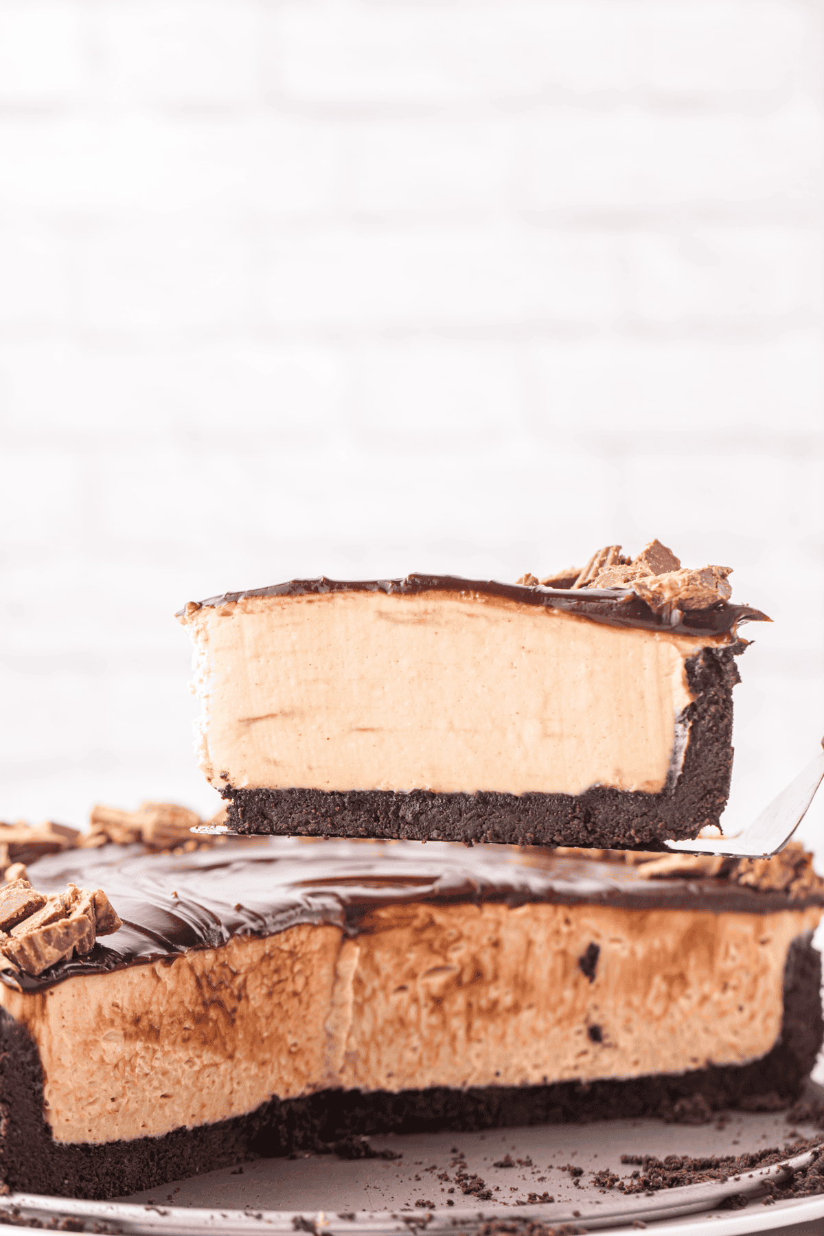 slice of no bake peanut butter cheesecake on a cake server