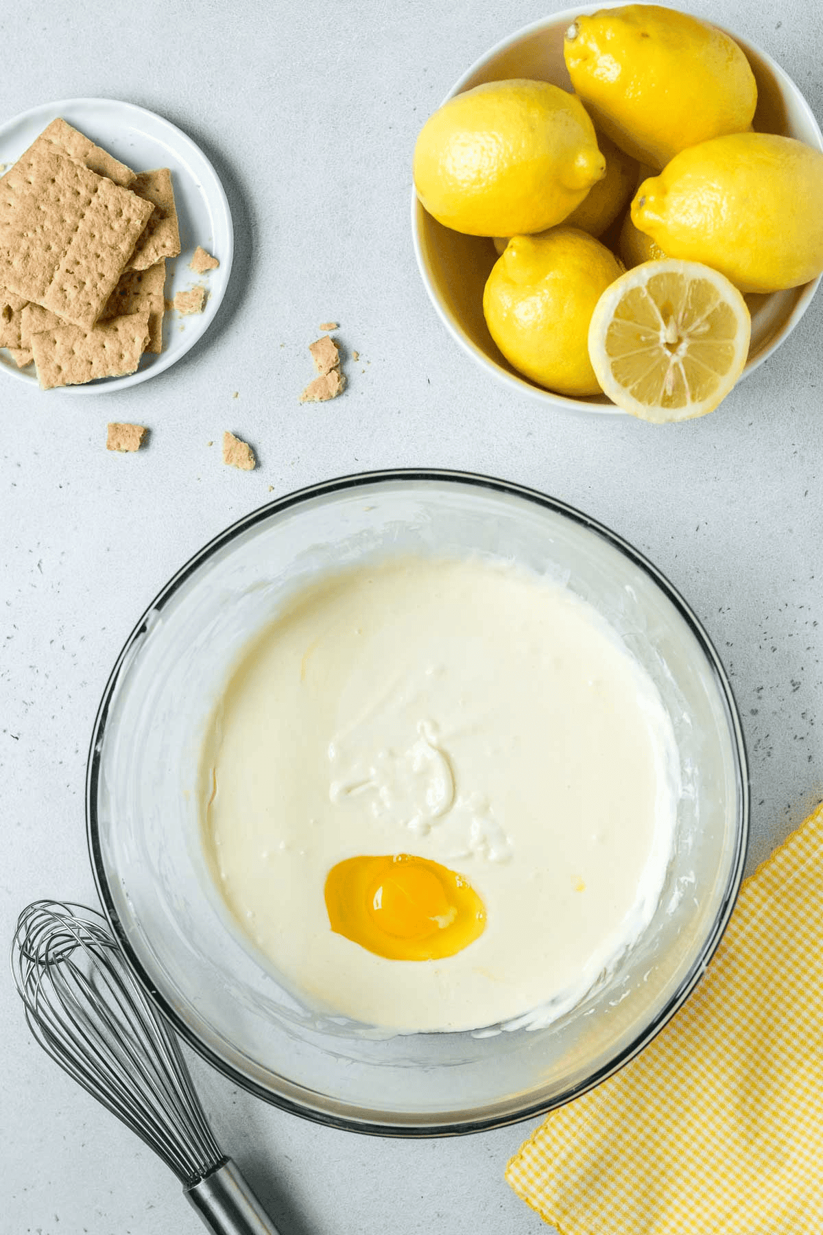 eggs and sour cream in bowl with lemon cheesecake batter