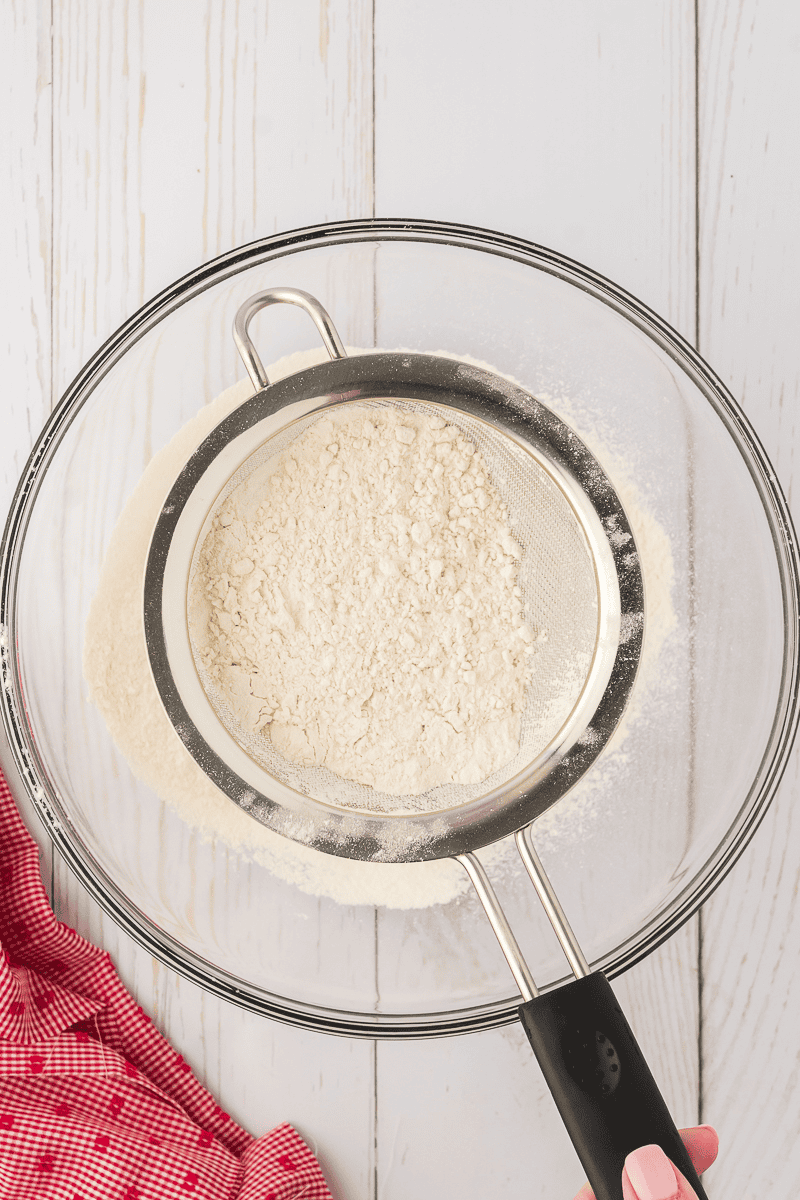 flour being sifted into large bowl