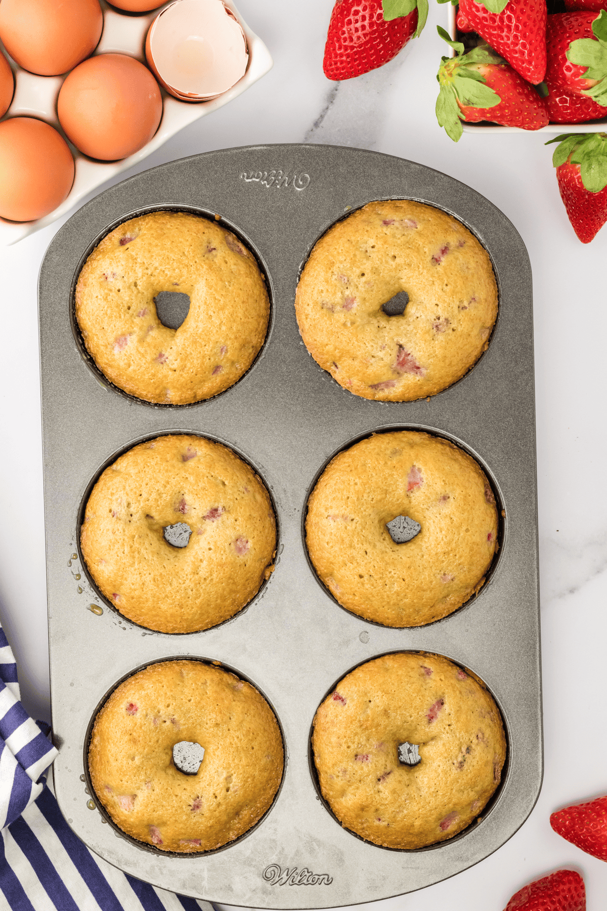six baked strawberry donuts in donut pan