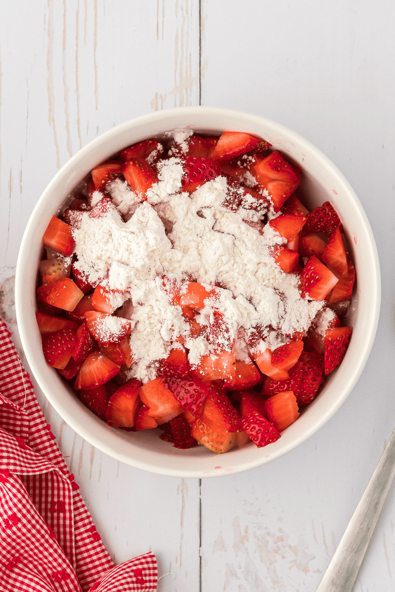 chopped strawberries and flour in bowl