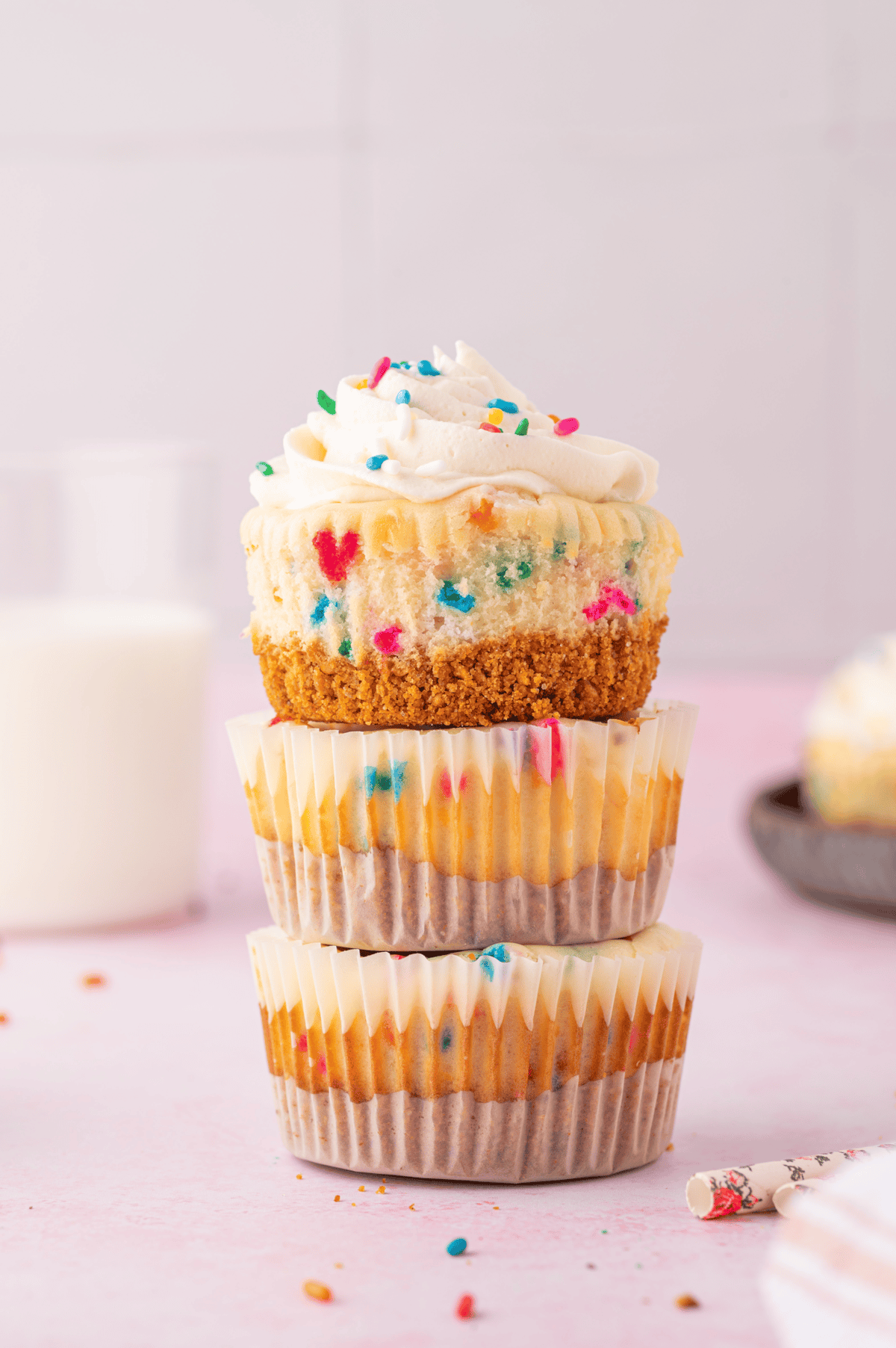 three mini funfetti cheesecakes in paper liners stacked
