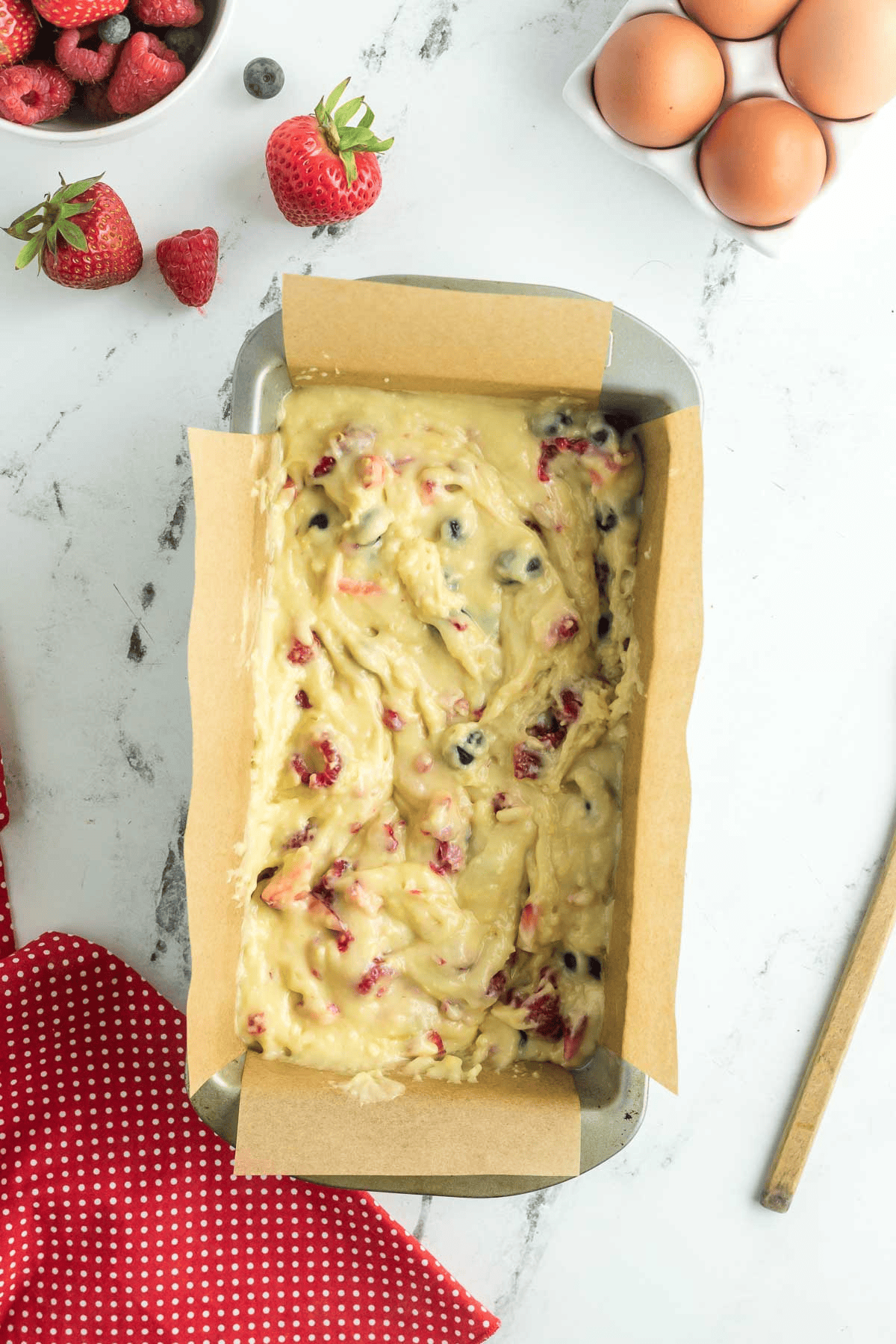 triple berry loaf cake batter in prepared pan