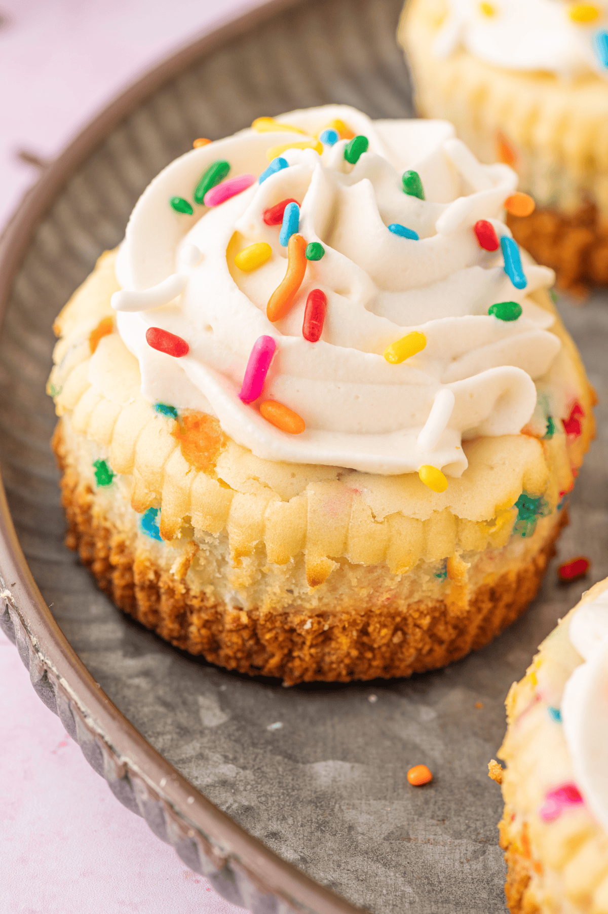 mini funfetti cheesecake topped with whipped cream and colorful sprinkles