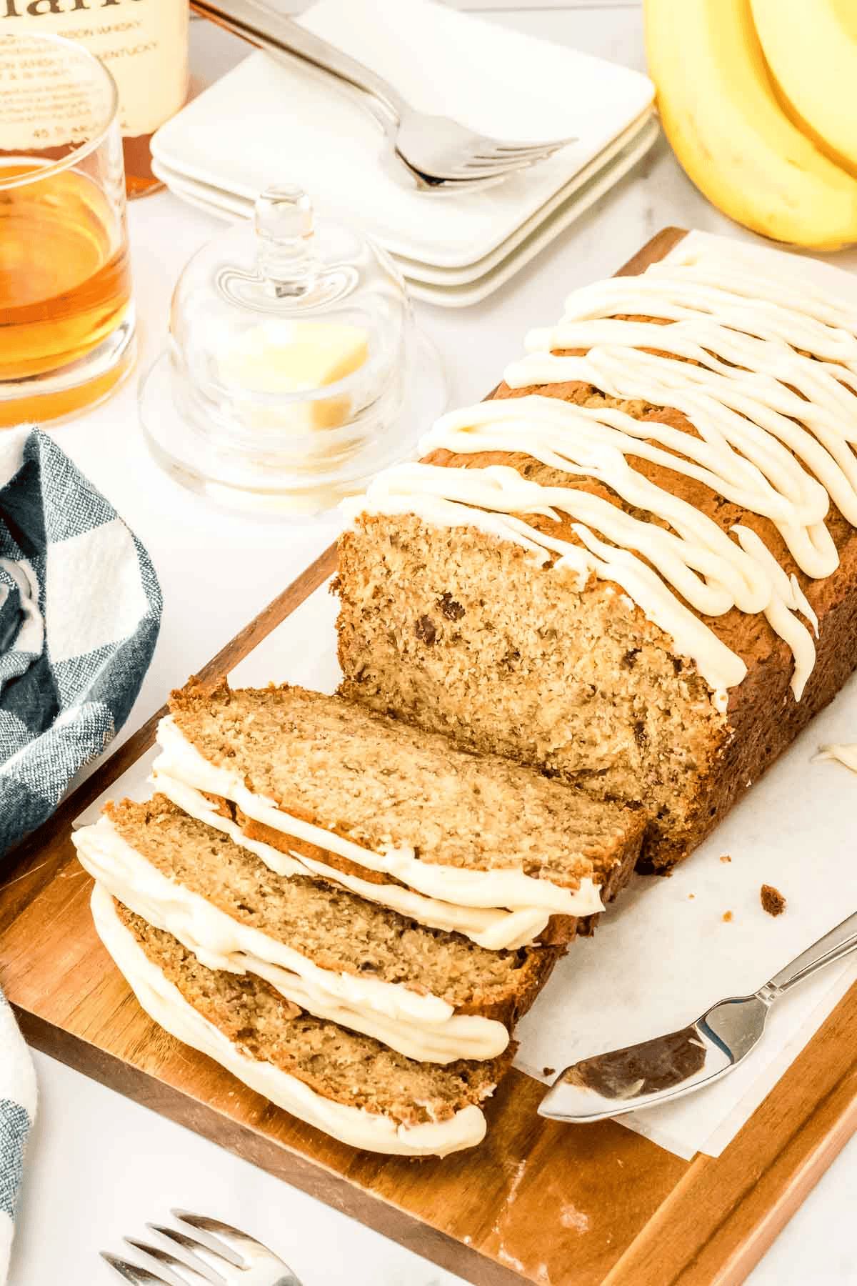 sliced bourbon banana bread with glaze on cutting board