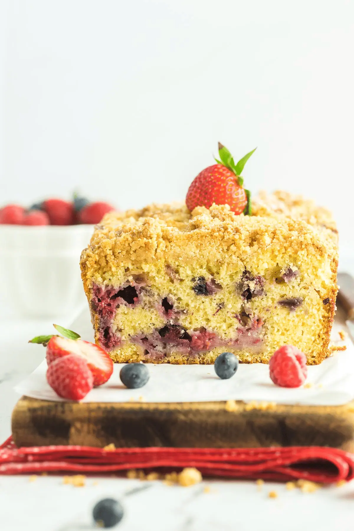 triple berry bread cut in half on cutting board