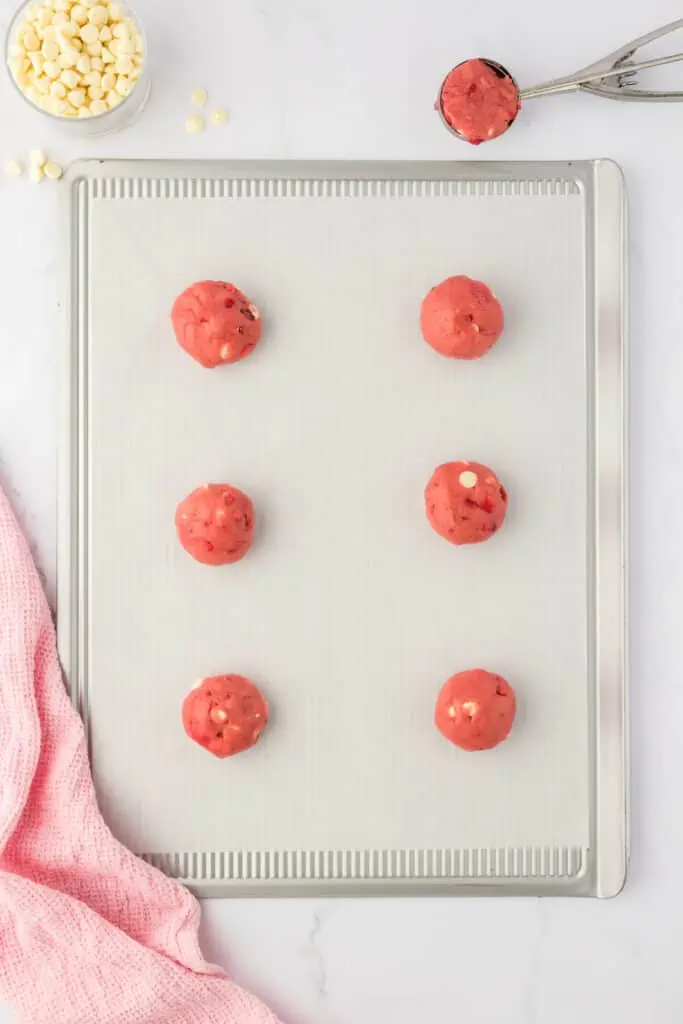 six unbaked cookies on a cookie sheet