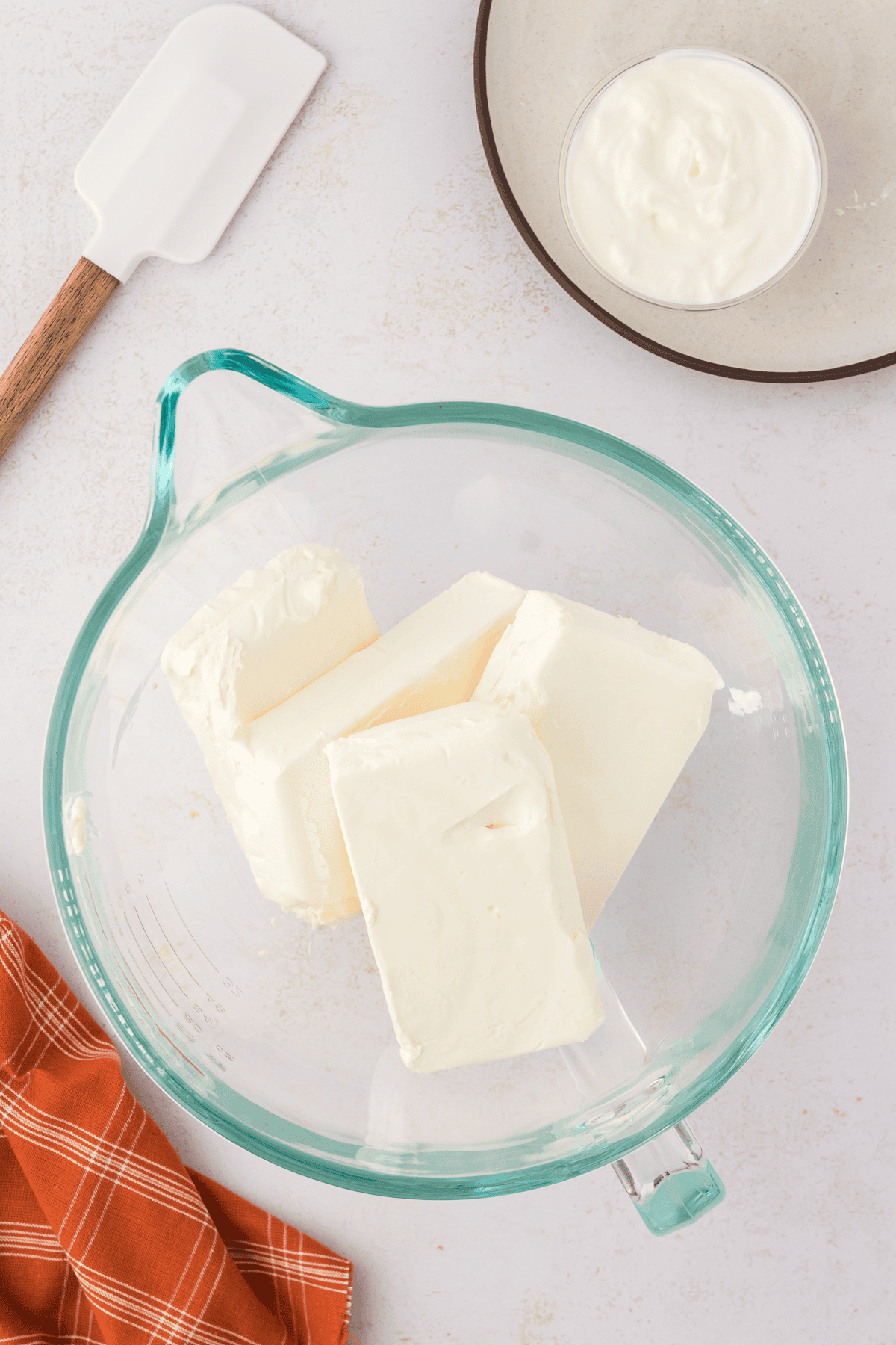 four blocks of cream cheese in a large bowl