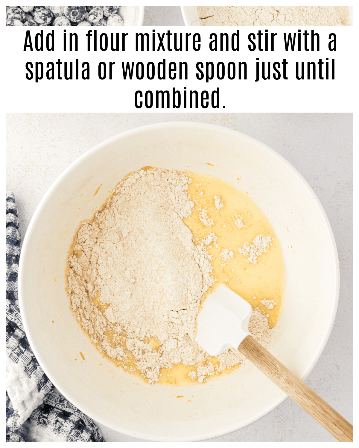 flour mixture added to bowl of muffin batter with a spatula