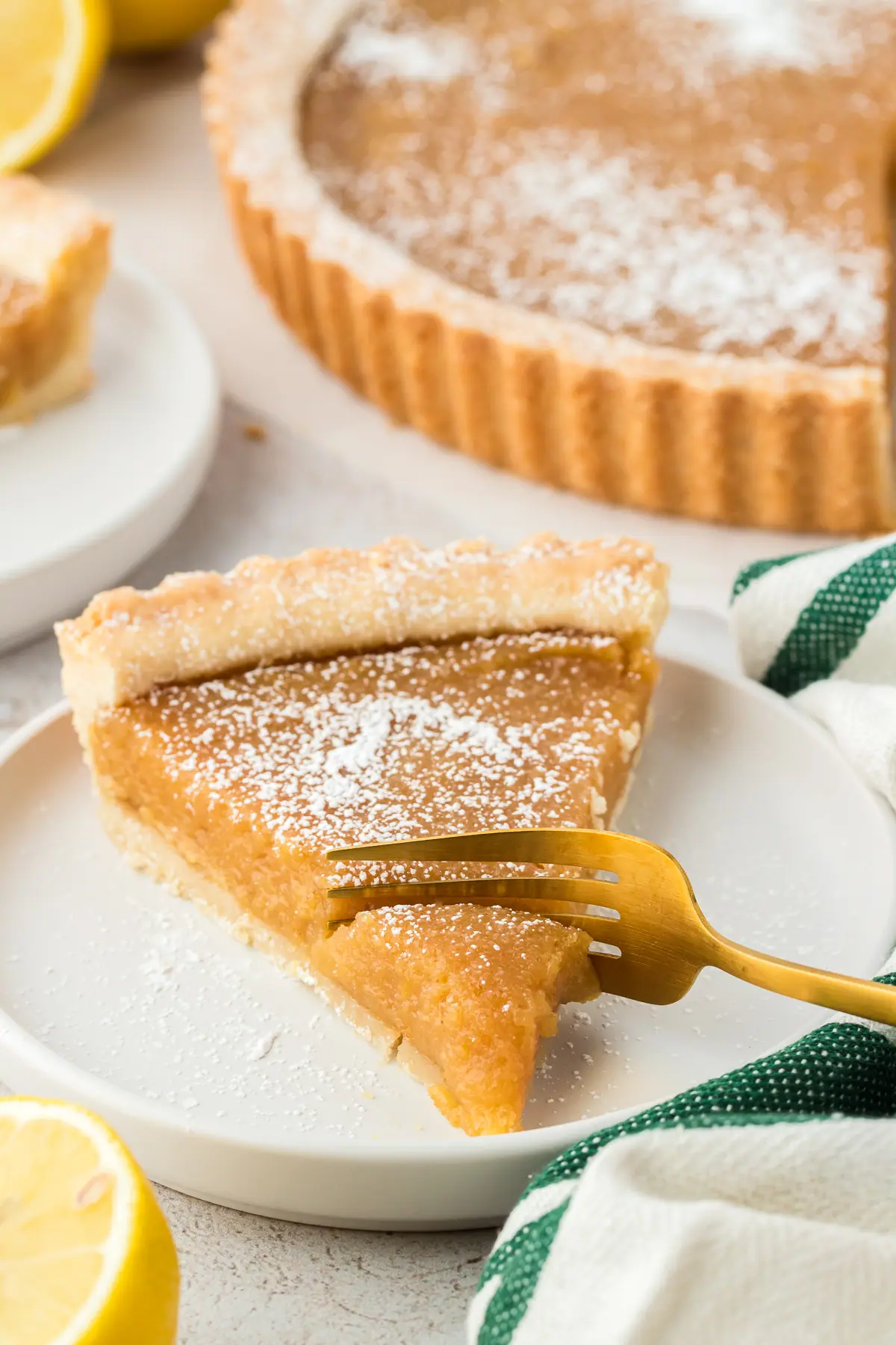 fork slicing into a slice of treacle tart on a plate