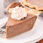 slice of cinnamon pie topped whipped topping on a plate with a fork