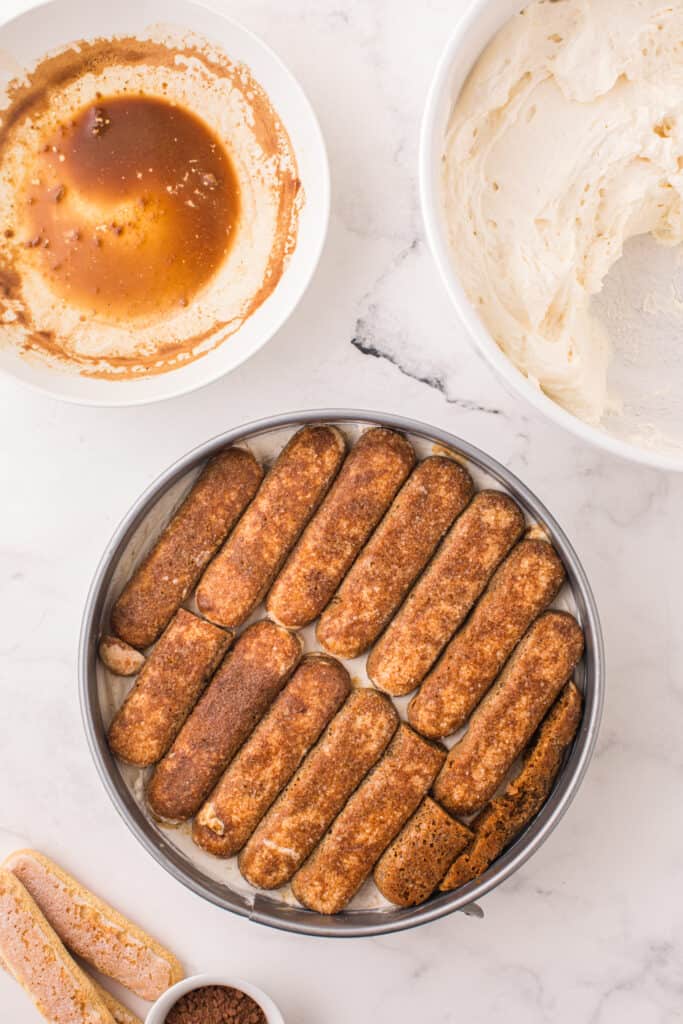 coffee soaked lady fingers layered on top of cheesecake batter