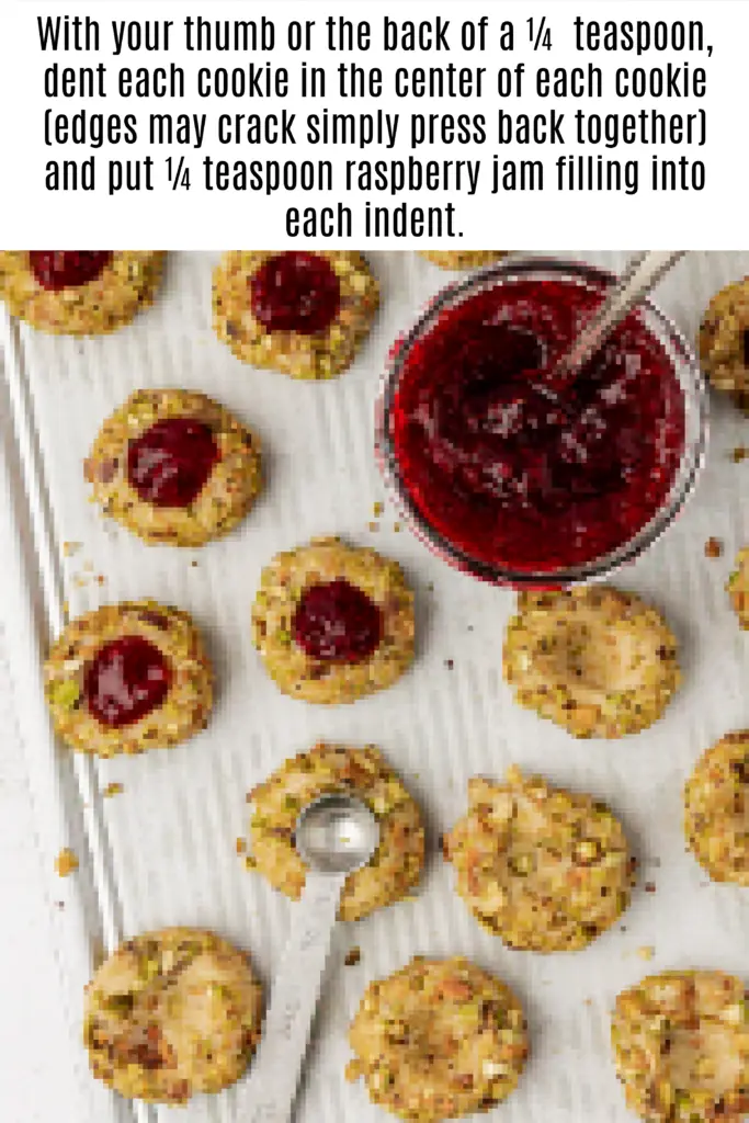 raspberry jam added to center of pistachio thumbprint cookie centers