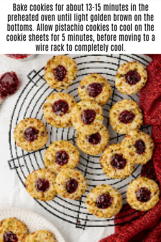 baked pistachio thumbprint cookies on a wire rack
