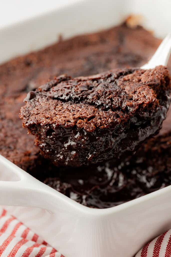 spoon lifting out a serving of chocolate cobbler