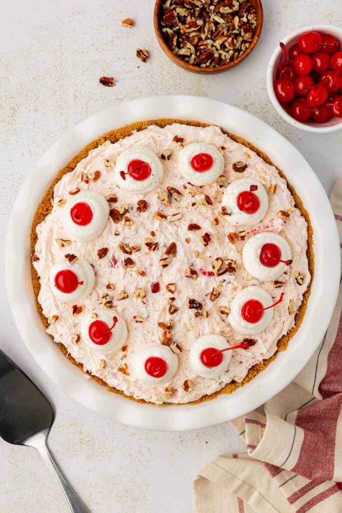 millionaire pie garnished with whipped cream, cherries and pecans