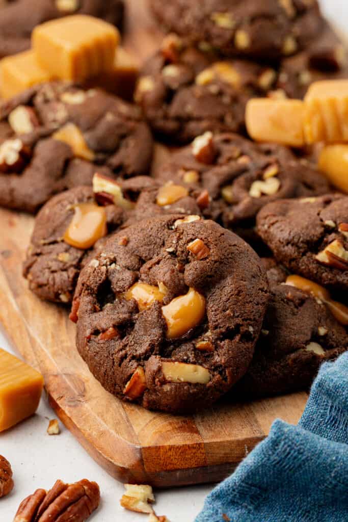 chocolate turtle cookies on a wooden cutting board
