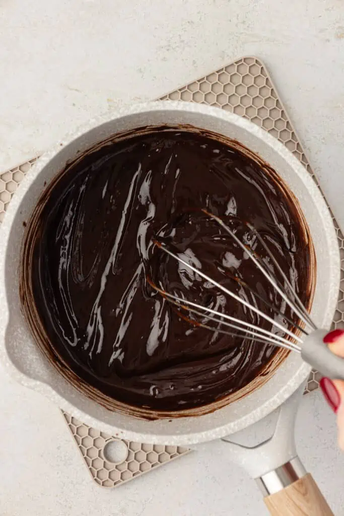 cocoa powder added to melted butter chocolate mixture in saucepan