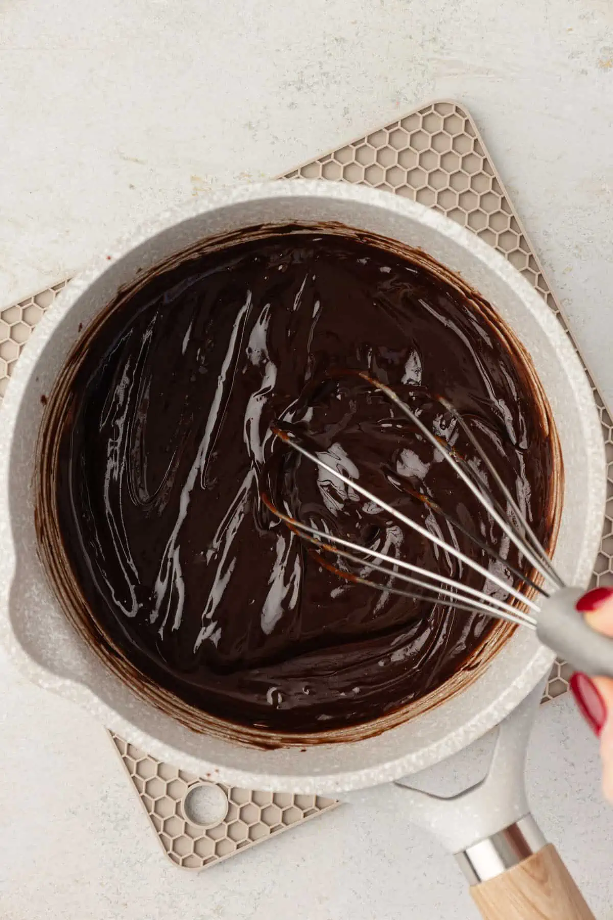 cocoa powder added to melted butter chocolate mixture in saucepan