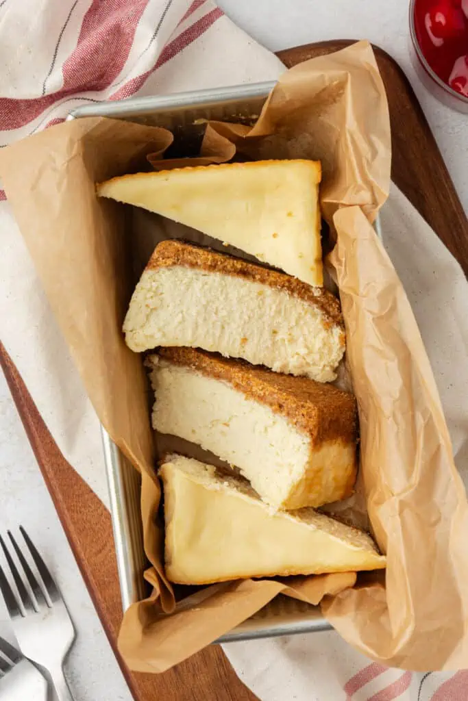 small batch cheesecake cut into slices in a loaf pan