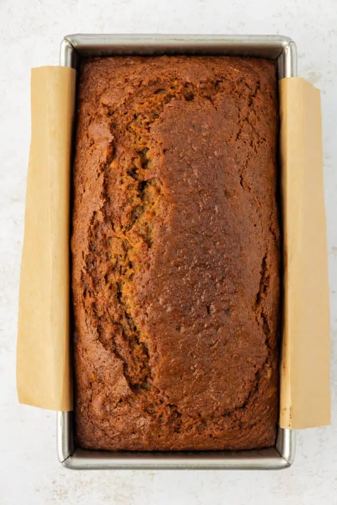 carrot cake loaf in loaf pan lined with parchment paper
