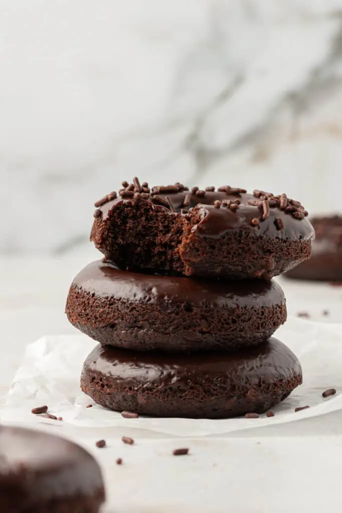 three baked chocolate donuts stacked on top of each other