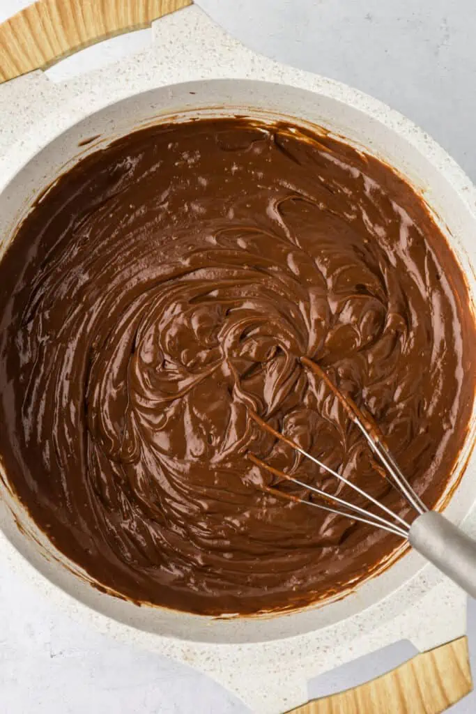 chocolate pudding in a bowl with a whisk