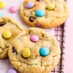three easter m&m cookies on a wire rack