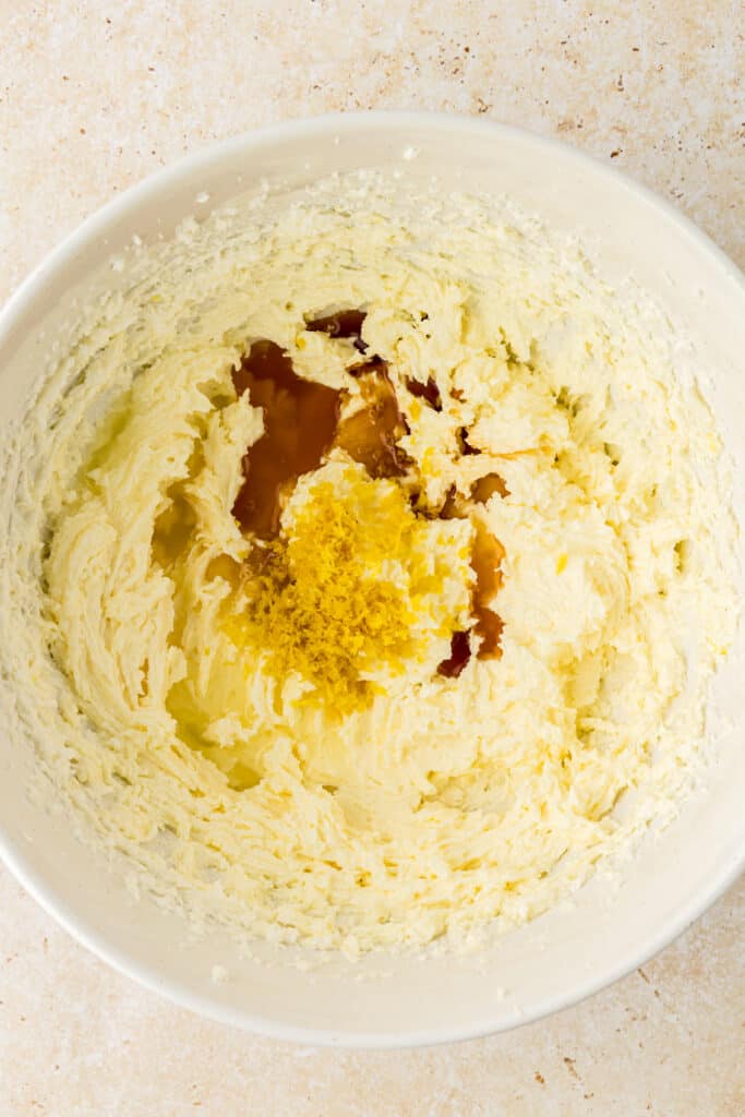 vanilla, lemon juice, and lemon extract added to cookie dough in bowl