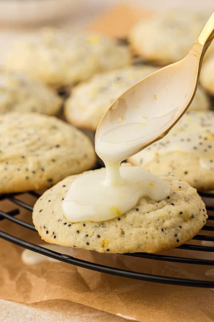 icing being drizzled on lemon poppyseed cookie