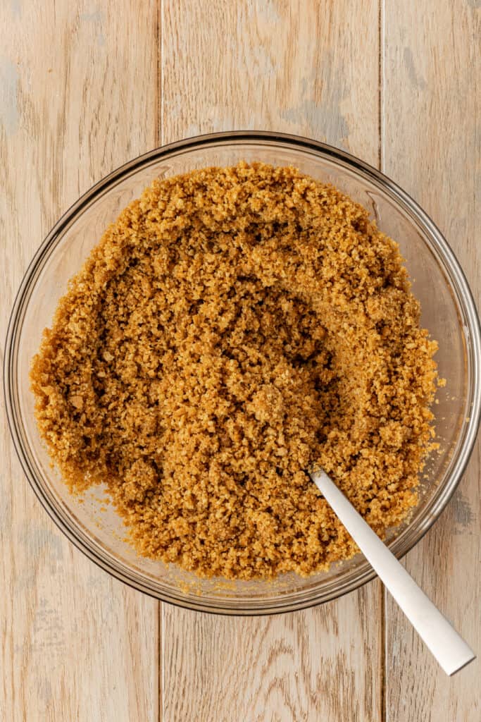 graham cracker crust mixture in a bowl with a spoon