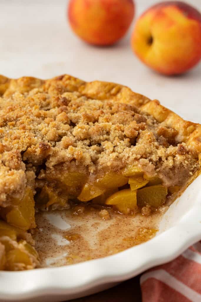 peach crumble pie with a piece missing