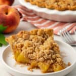 slice of peach crumble pie on a plate