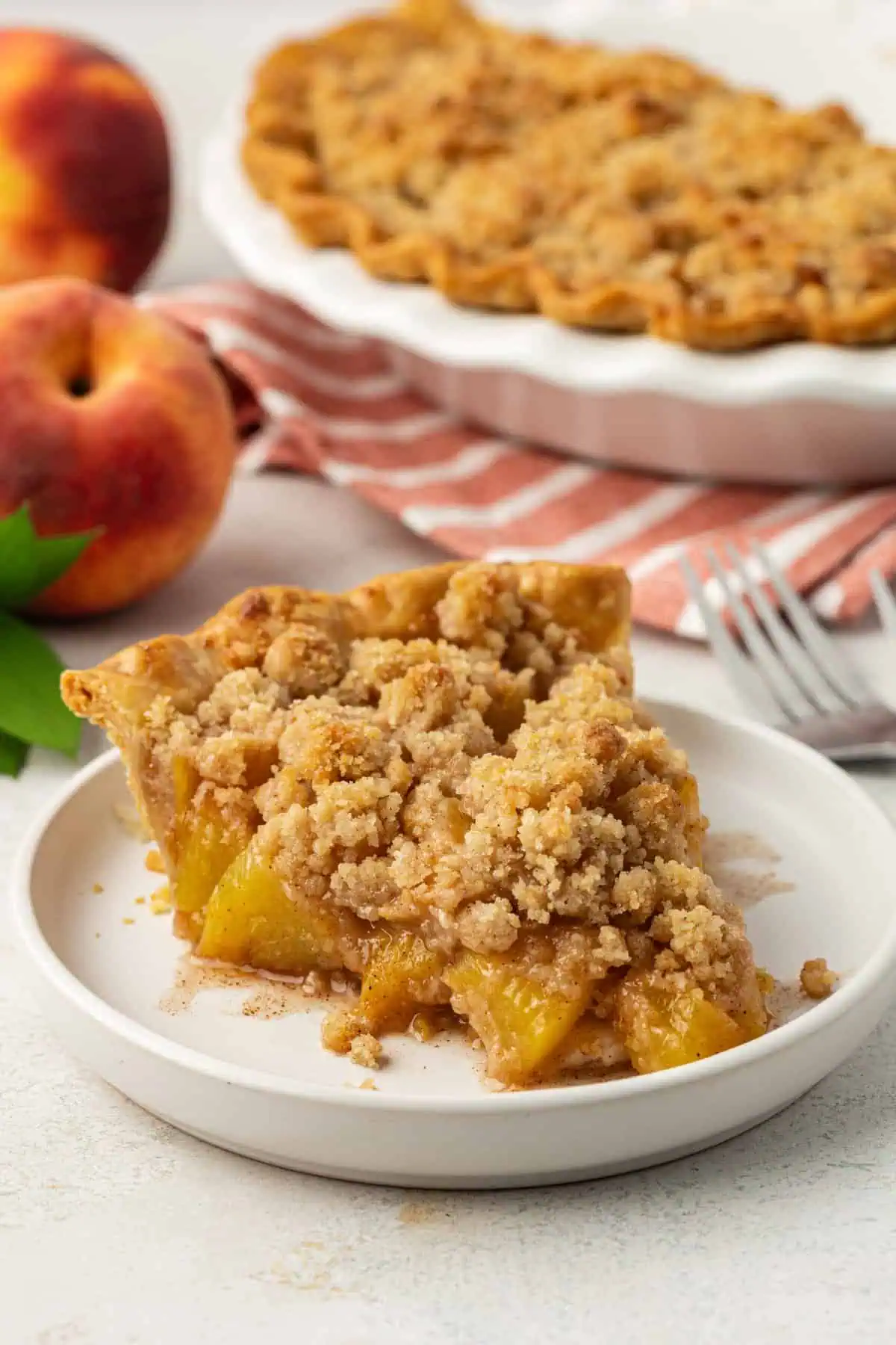 slice of peach crumble pie on a plate